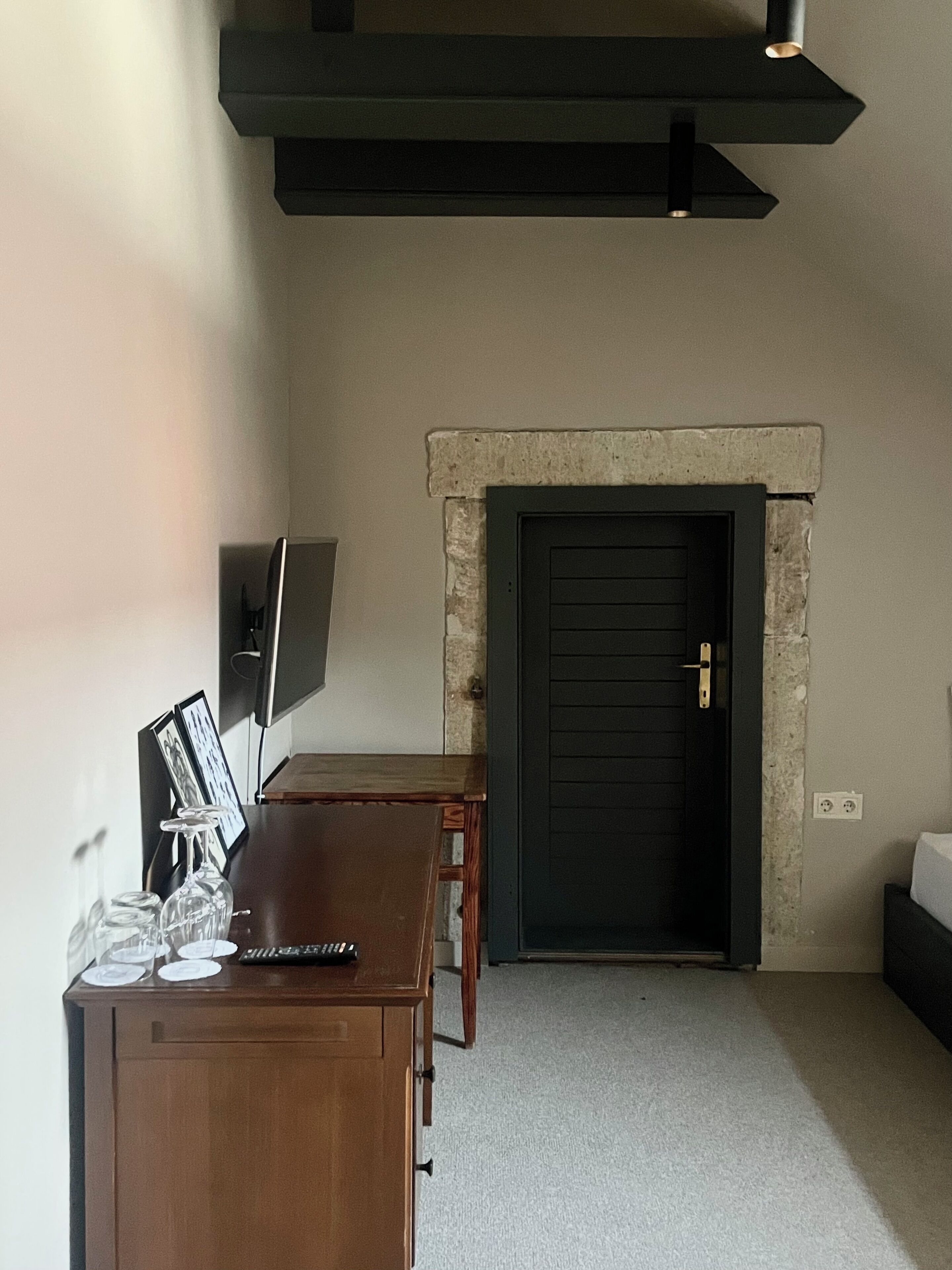 Una habitación con chimenea, un escritorio de madera con una computadora y un televisor montado en la pared.
