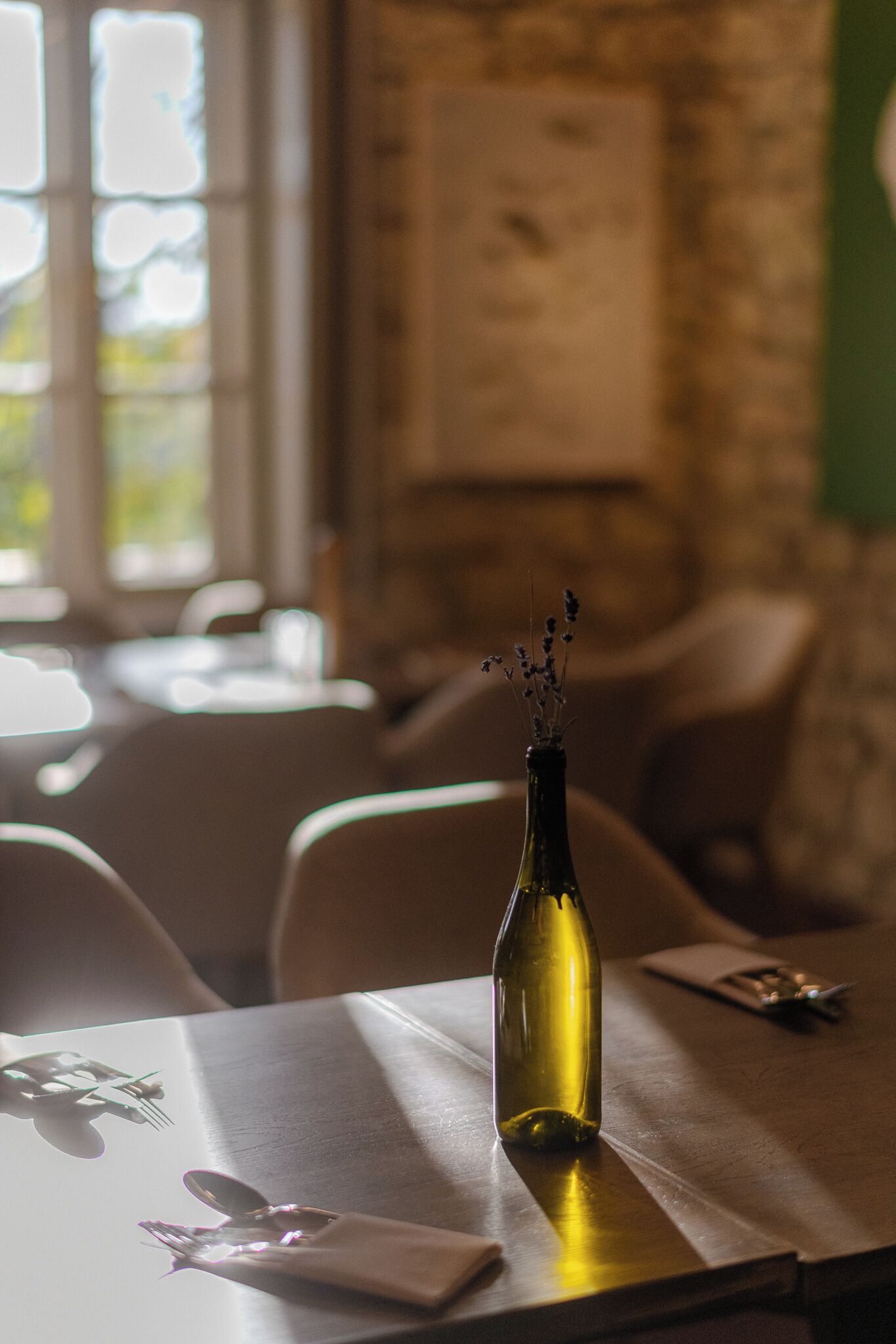 Une table avec une bouteille de vin, une serviette et des couverts.