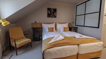 Une chambre d’hôtel avec un grand lit, une chaise, un bureau et un tableau au mur.