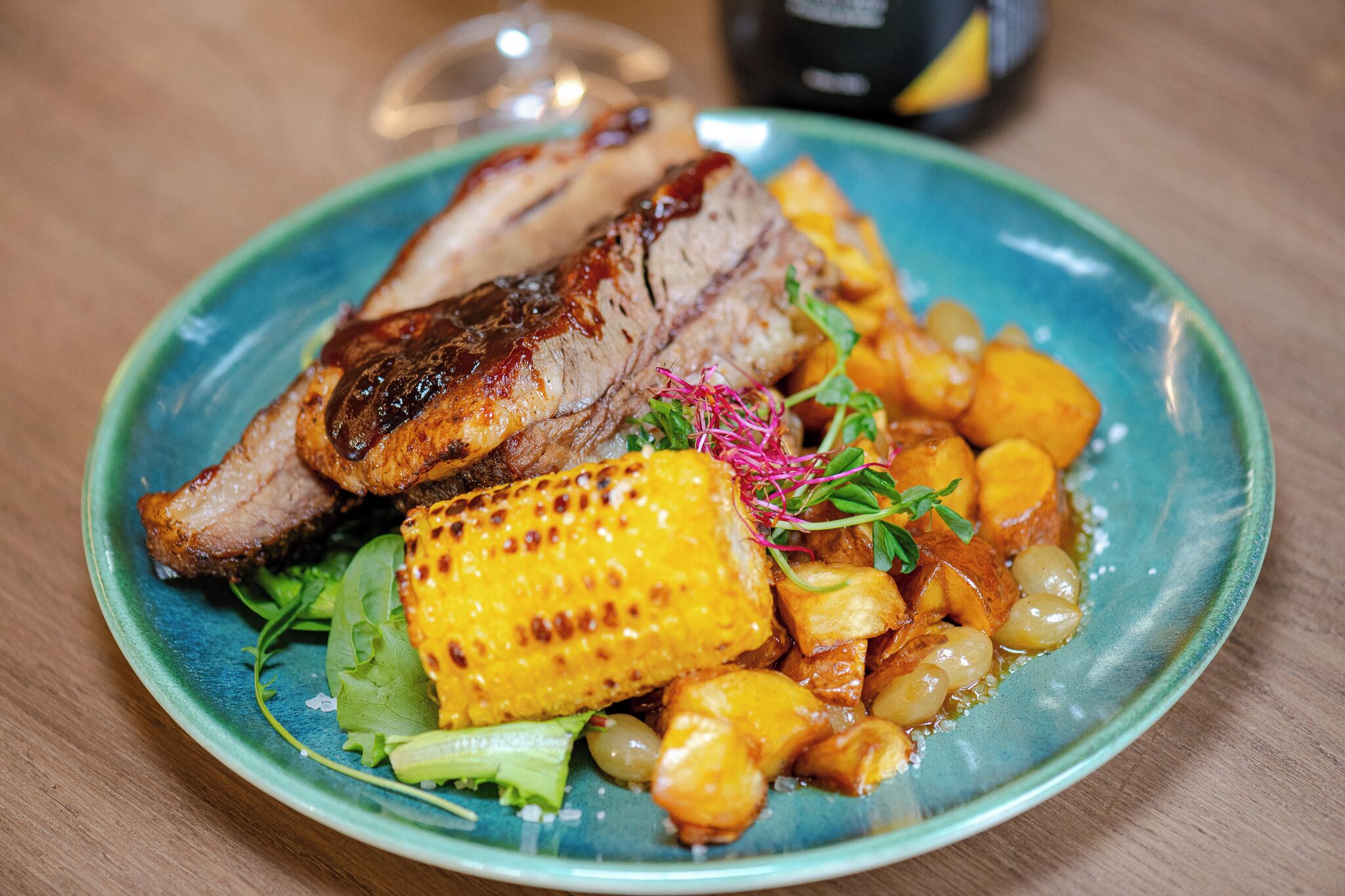 A plate of food with grilled meat, corn, and potatoes.