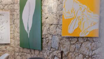 Interior de un restaurante con paredes de piedra, dos mesas y sillas.