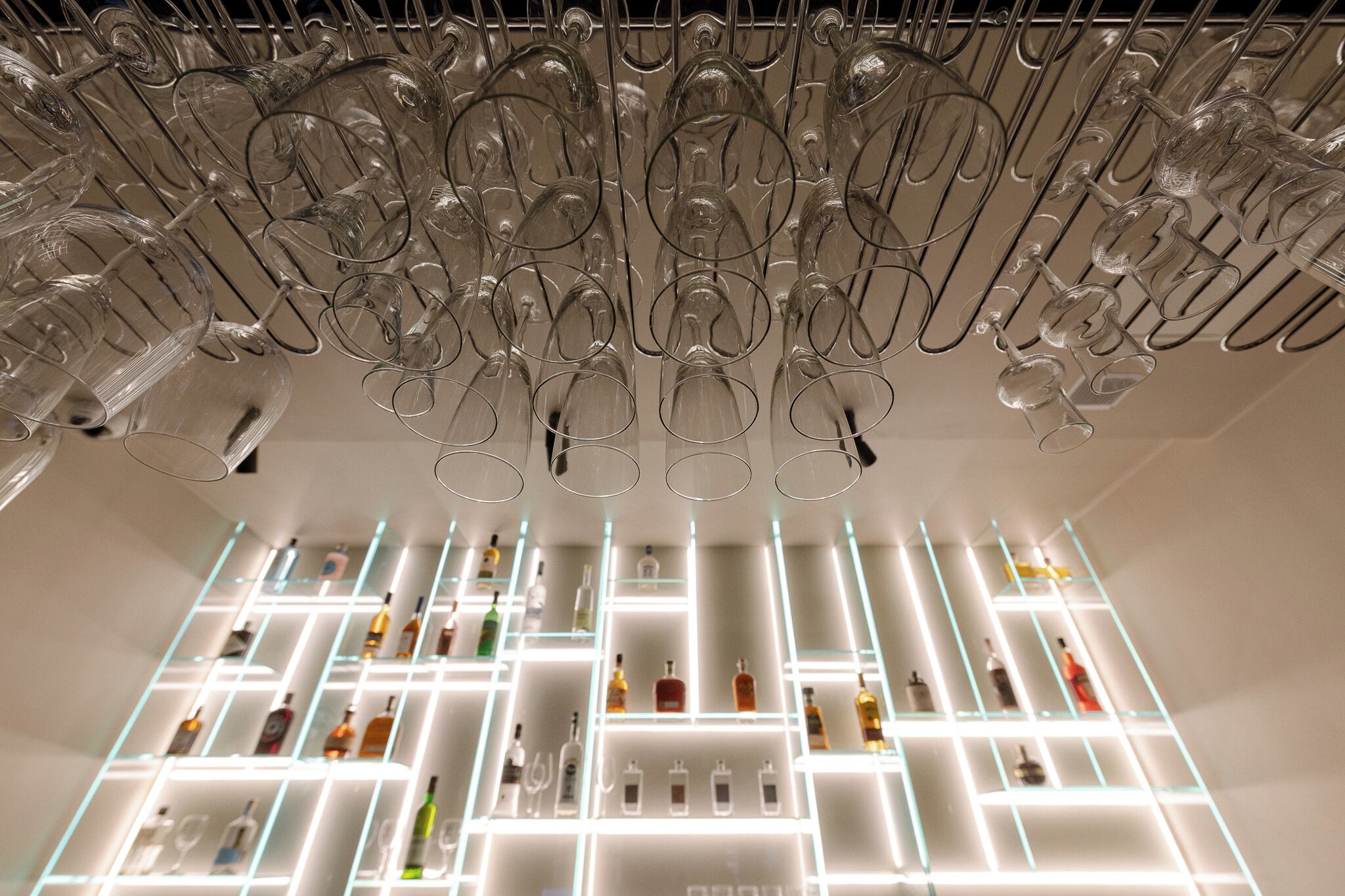 A modern interior with a wine rack and shelves of bottles.