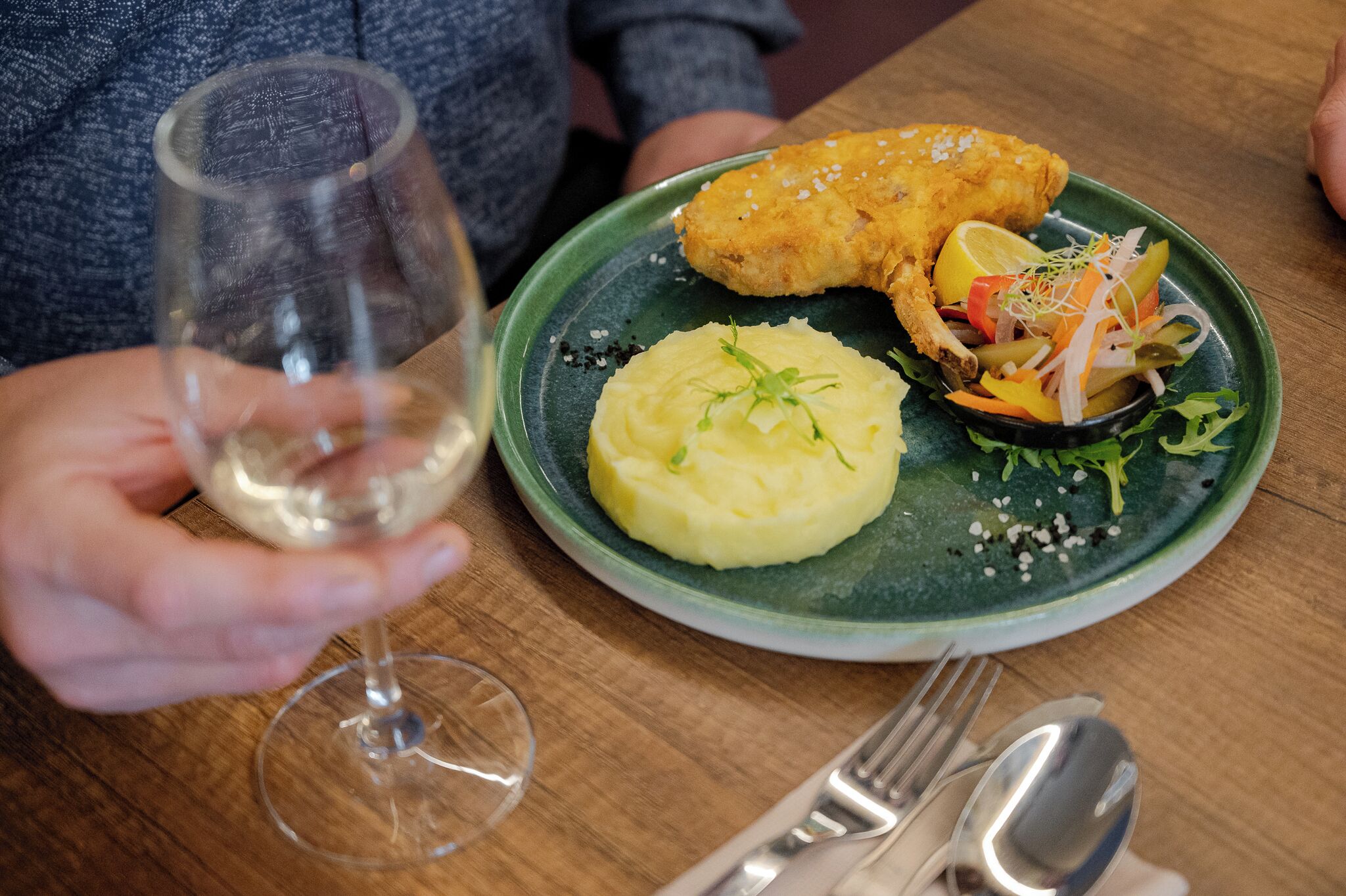 A plate with mashed potatoes, a breaded item, and a vegetable salad on a green plate.