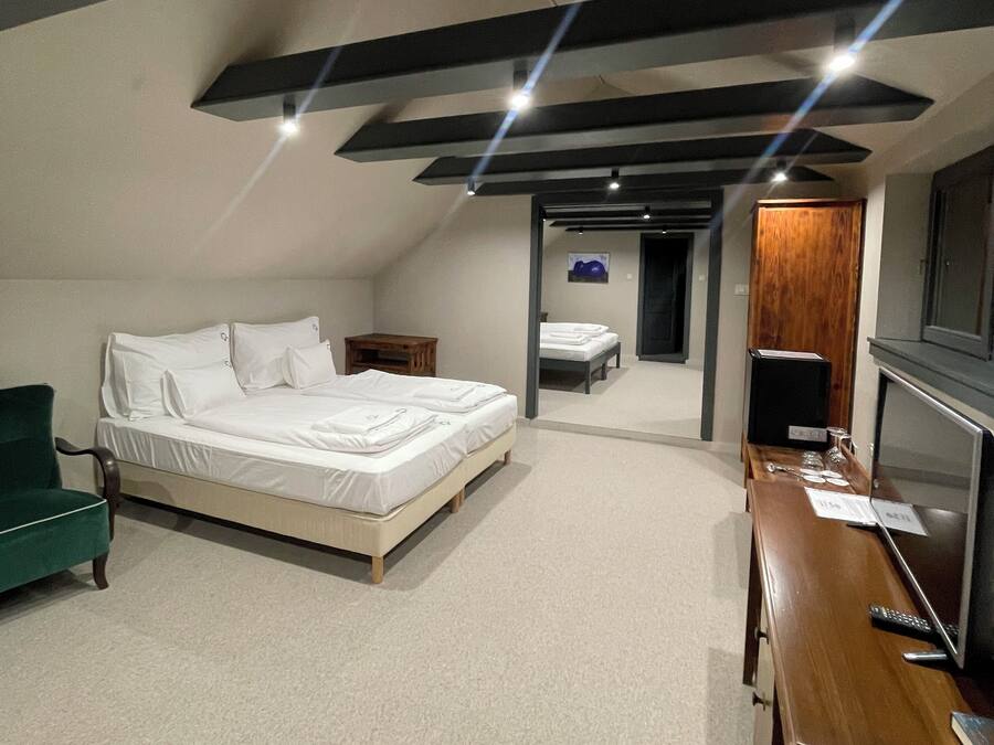 A modern hotel room with a large bed, a desk, and a television.