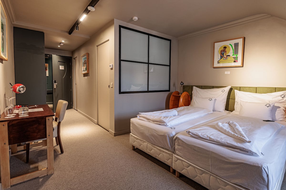 A hotel room with a bed, a desk, and a chair.