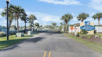 Een omheind toegangspunt naar The Villages of Mariner Lakes, met palmbomen en een heldere lucht.