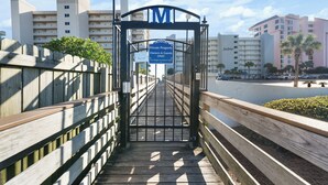 Ein hölzerner Steg führt zu einem verschlossenen Eingang, an dem ein Schild mit dem Aufdruck 'Private Property Owners & Guests Only' angebracht ist.
