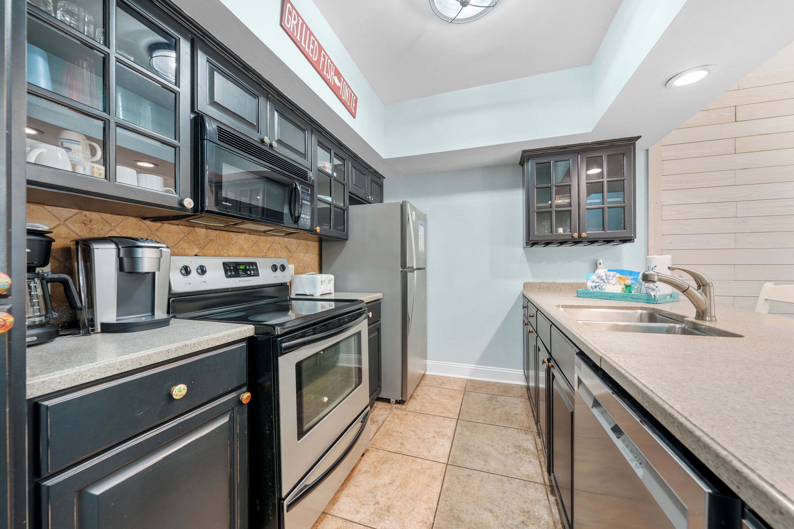A modern kitchen with stainless steel appliances, a built-in microwave, and a granite countertop.