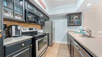 A modern kitchen with stainless steel appliances, a built-in microwave, and a granite countertop.