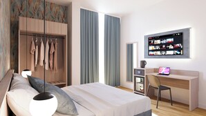 A modern hotel room with a bed, a desk with a laptop, a wardrobe, and a wall-mounted TV displaying a movie selection. - The Place Vaticano 278 (Rome)