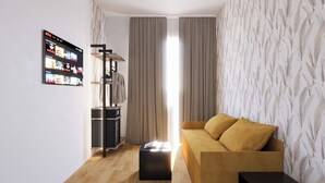 A modern living room with a sofa, a TV mounted on the wall, and a wardrobe. - The Place Vaticano 278 (Rome)