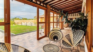 A covered outdoor area with wooden beams, large windows, and wicker furniture. - CasaMarella Exclusivity+HouseBoutique+Hydromassage

 (Morelia Pereira)