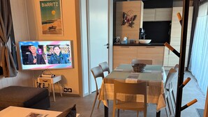 Una sala de estar moderna con un sofá, una mesa de comedor y una zona de cocina.