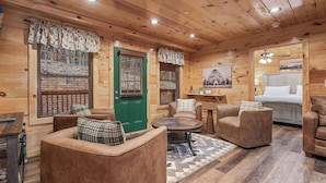 A cozy log cabin interior with a green door, wooden walls, and a dining area with a table and chairs. - Tennessee Time is always right (PIGEON FORGE)