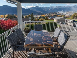 Relax in a serene outdoor seating area with a table and four chairs, surrounded by breathtaking views of the mountains and valley.