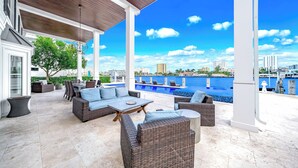 An outdoor patio with wicker furniture, a pool, and a city view. - Waterfront Gem! Heated Pool+HotTub! Close 2 Beach! (Pompano Beach)