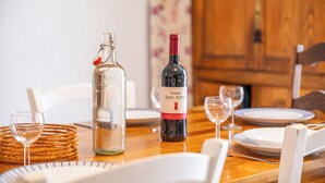 A dining table set with plates, glasses, and a bottle of wine. - 3 *** village house, bright veranda opening onto terrace and large garden (Quiberon)