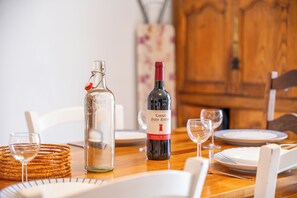 A dining table set with plates, glasses, and a bottle of wine. - 3 *** village house, bright veranda opening onto terrace and large garden (Quiberon)