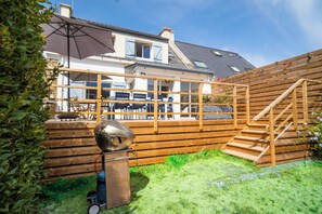 A wooden deck with outdoor seating and a barbecue grill. - 3 *** Country house, bright porch with a patio and a large garden (Quiberon)