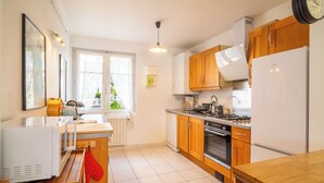 A modern kitchen with wooden cabinets, a built-in oven, a sink, and a stove. - 3 *** village house, bright veranda opening onto terrace and large garden (Quiberon)