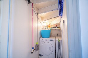 Ett utrymme för tvätt med en tvättmaskin, en mopp och rengöringsmedel.