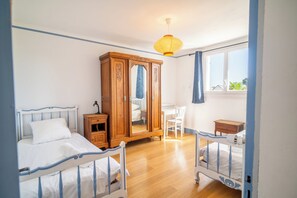 A bedroom with two beds, a wardrobe, a desk, and a window. - 3 *** village house, bright veranda opening onto terrace and large garden (Quiberon)