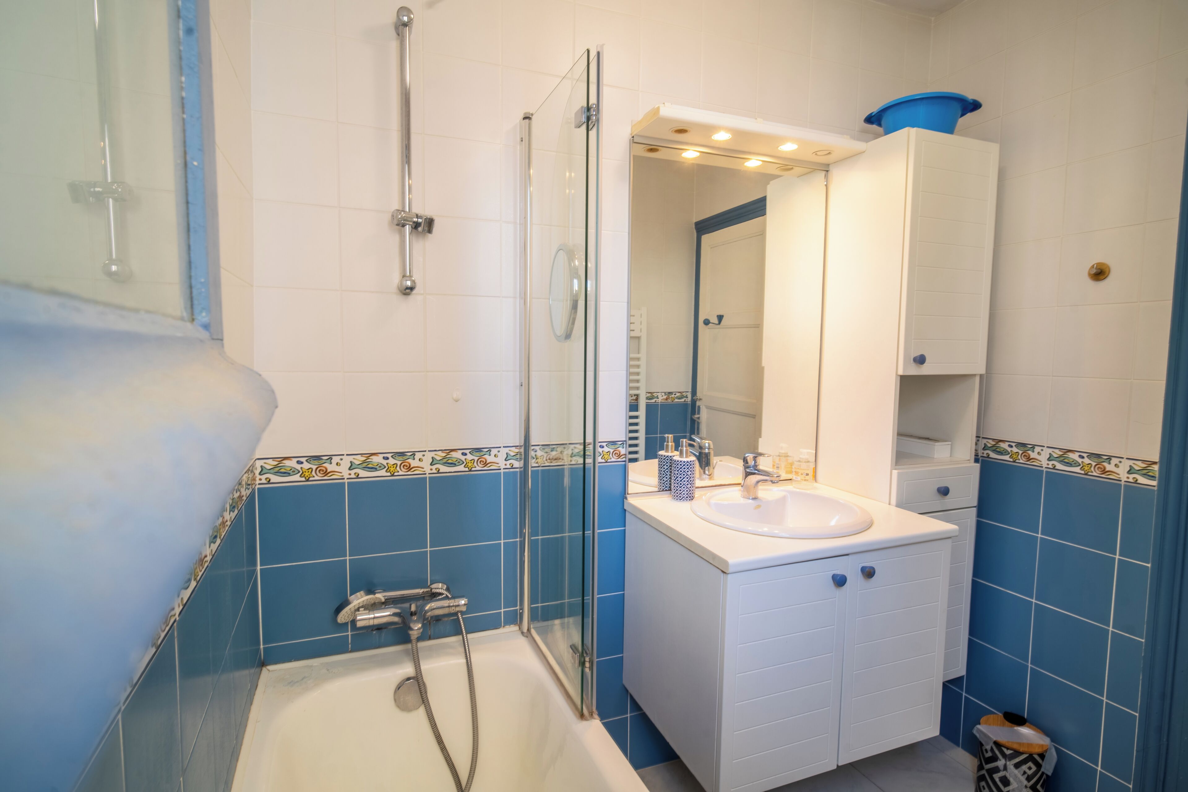 Une salle de bain avec une baignoire, une douche et un lavabo avec un miroir au-dessus.