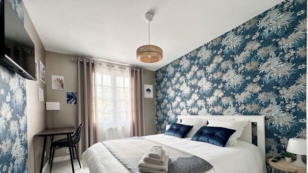 A bedroom with a large bed, a desk, and a chair. - Charming Datcha in Normandy  (Les Damps)