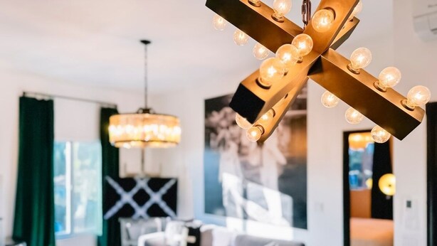 A modern living room with a sofa, a coffee table, and a unique light fixture.