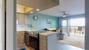 A compact kitchen with a dining area, a balcony with a view, and a ceiling fan. - Sea Colony B7-one bedroom one bath, 1st floor, oceanfront rental located in Carolina Beach with panoramic views (Carolina Beach)