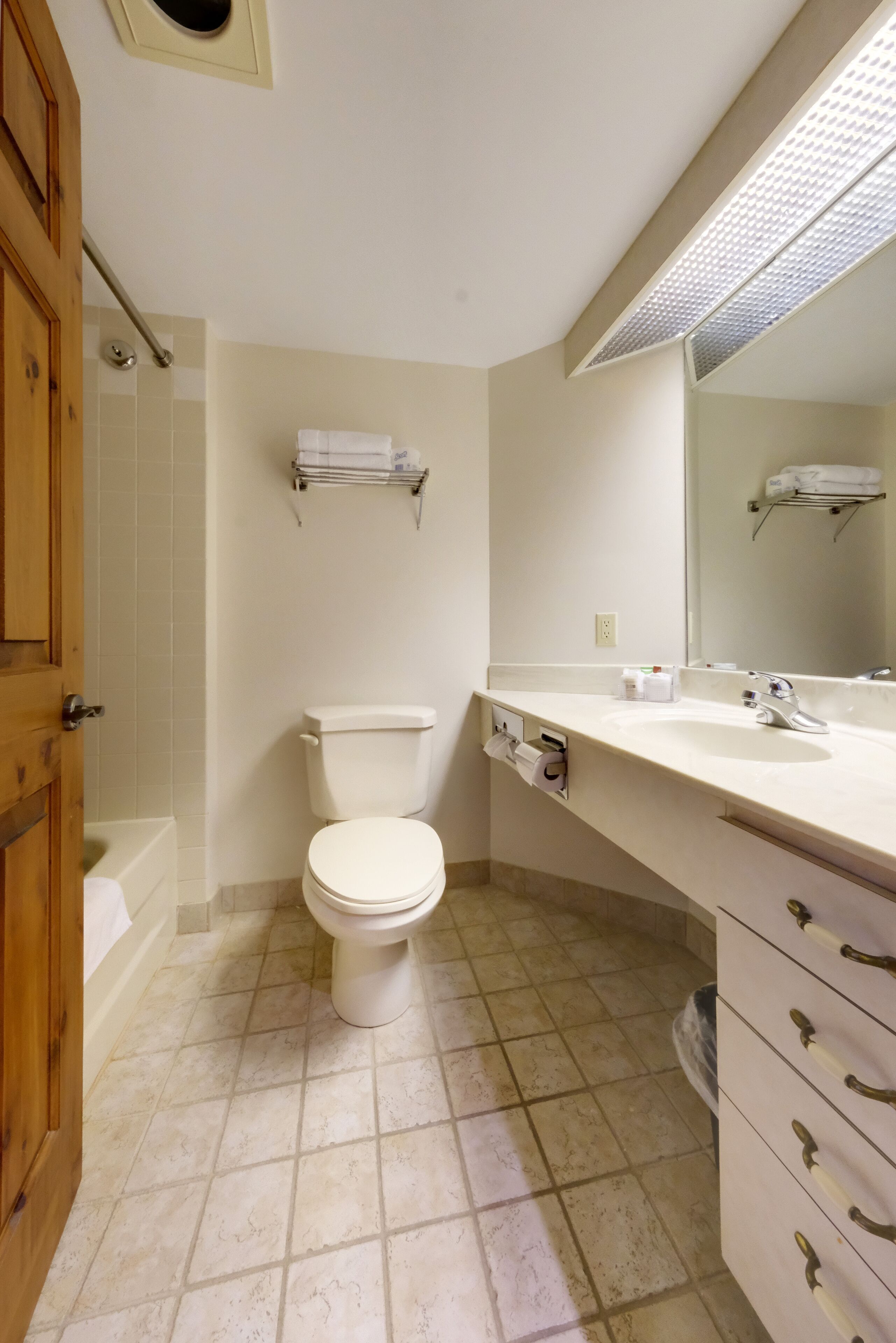 Un baño con inodoro, lavamanos y zona de ducha.