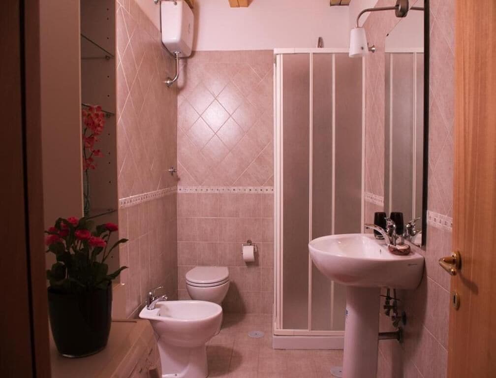 A bathroom with a toilet, sink, and shower.
