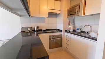 Appartement, vue ville | Cuisine privée | Grand réfrigérateur, micro-ondes, four, plaque de cuisson