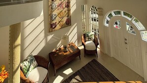 A spacious room with a high ceiling, large windows, a chandelier, and a painting on the wall. - 🌴 Spacious Barbados Villa 400m from Mullins Beach/Sleeps 16/ideal for families🌴 (Mullins)