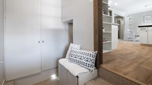 A modern room with a large wardrobe, a bench with a patterned cushion, and a wooden floor. - Poolside Paradise with Hot Tub (Boise)