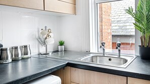 A modern kitchen with a built-in sink, stainless steel appliances, and a window with a view of a brick building. - Leicester/1bedapart/petsok/tv/wifi/restaurantsnear (Leicester)