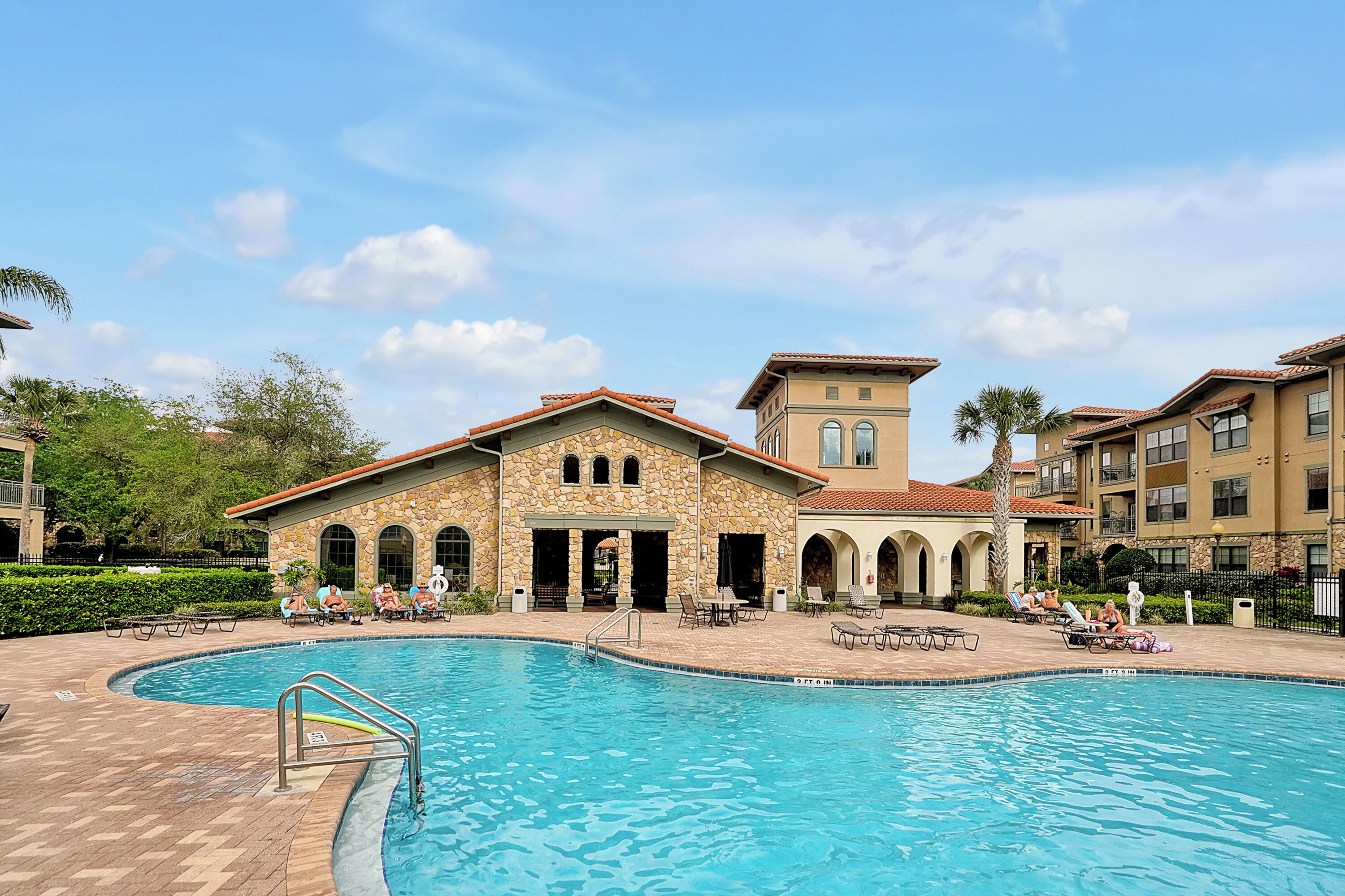 A swimming pool with a stone building in the background.