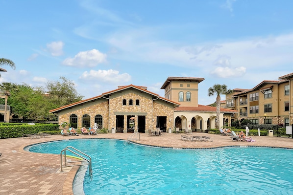 A swimming pool with a stone building in the background.