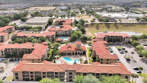 A residential area with multiple apartment buildings, a swimming pool, and a parking lot. - Spacious 4 Bedroom Condo Resort Close to Disney (Davenport)
