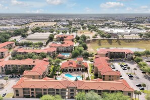 A residential area with multiple apartment buildings, a swimming pool, and a parking lot. - Spacious 4 Bedroom Condo Resort Close to Disney (Davenport)