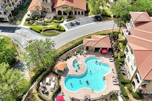 Luftaufnahme eines Resorts mit Schwimmbad, angelegten Gärten und einem Parkplatz.