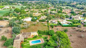 An aerial view of a residential area with houses, a swimming pool, and surrounding greenery. - Villa Malec by Villa Plus (El Vilà)