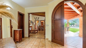 A hallway with a wooden door leading to a patio area. - Villa Malec by Villa Plus (El Vilà)