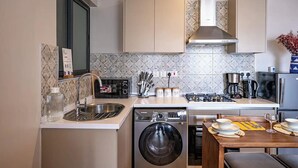 A compact kitchen with a dishwasher, microwave, stove, and sink. - Elite - 1 bedroom - pool & Gym

 (Nairobi)