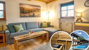 A cozy living room with a sofa, wooden coffee table, and a painting of a mountainous landscape.