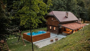 Une cabane en bois dotée d’une piscine, d’un espace extérieur aménagé et offrant une vue sur la forêt environnante.