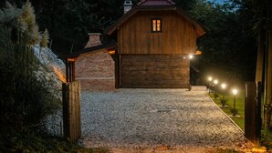 Une cabane en bois rustique, avec une allée en gravier et un mur de briques sur un de ses côtés.