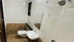 A bathroom with a toilet, sink, and shower. - Hotel Habitat Inn - Pune (Pune)