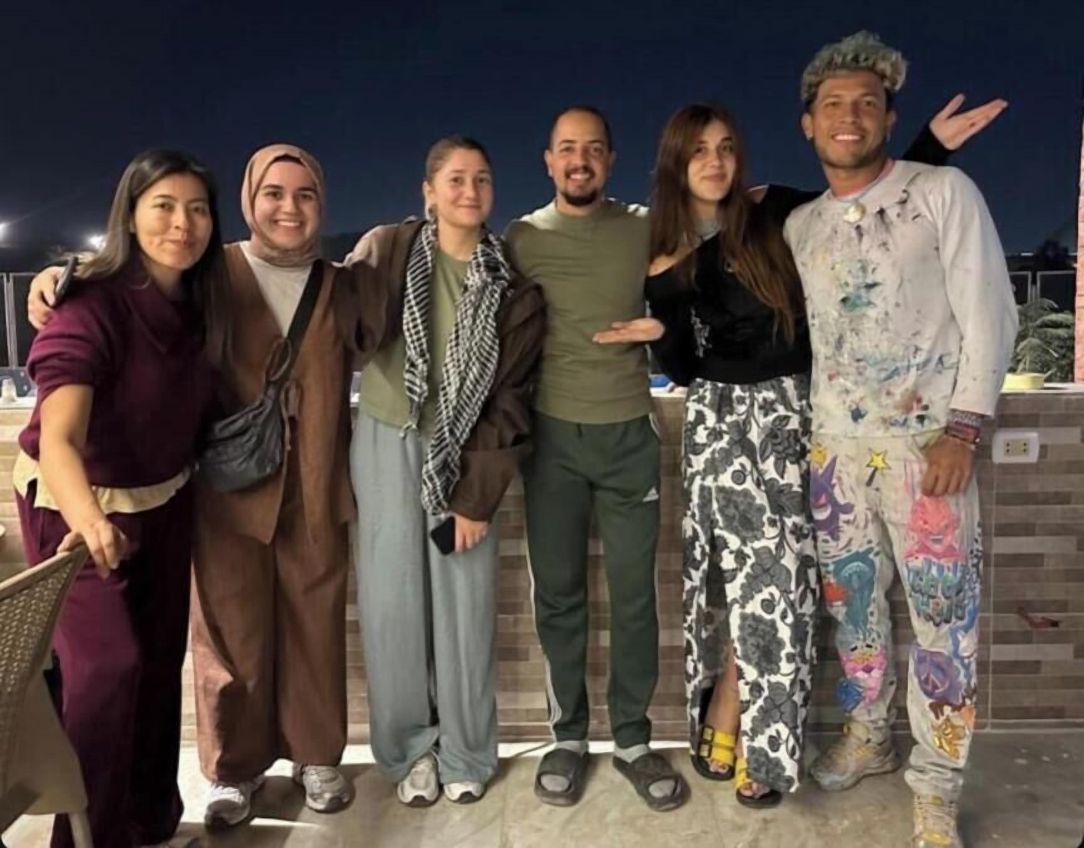 A group of people standing together outdoors at night.