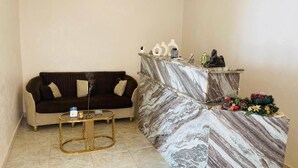 A living room with a sofa, coffee table, and a marble reception desk. - Farida Pyramids Boutique Hotel (Giza)